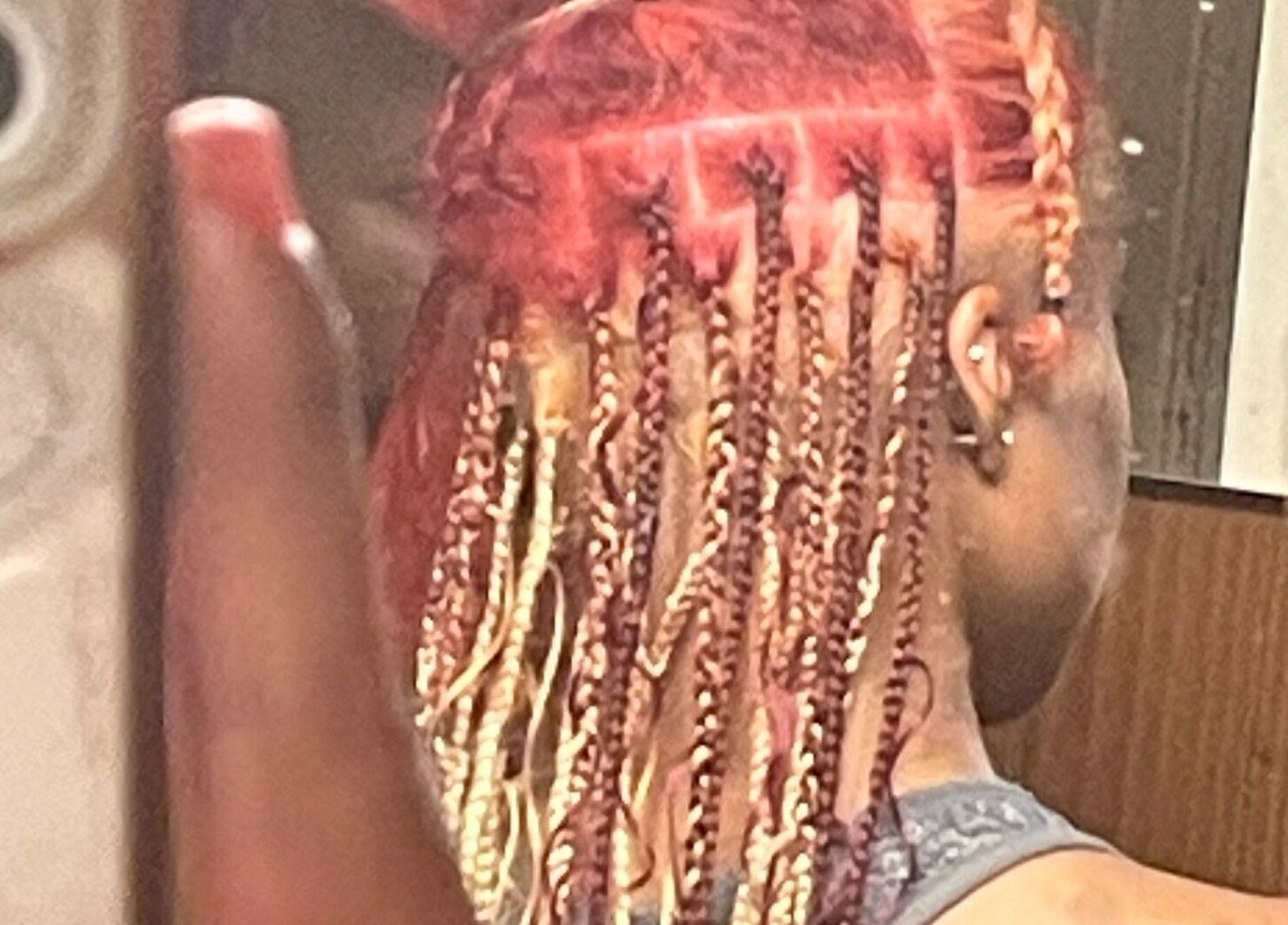 Intricate braided hairstyle at TTLC, Pembroke, BM showcasing vibrant red and blonde tones.