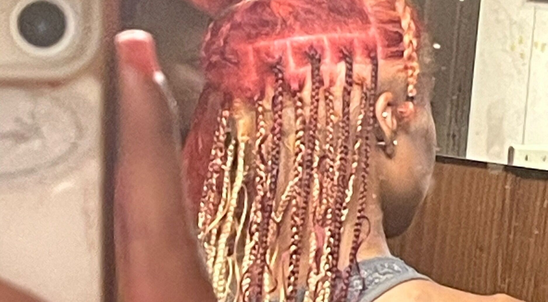 Intricate braided hairstyle at TTLC, Pembroke, BM showcasing vibrant red and blonde tones.