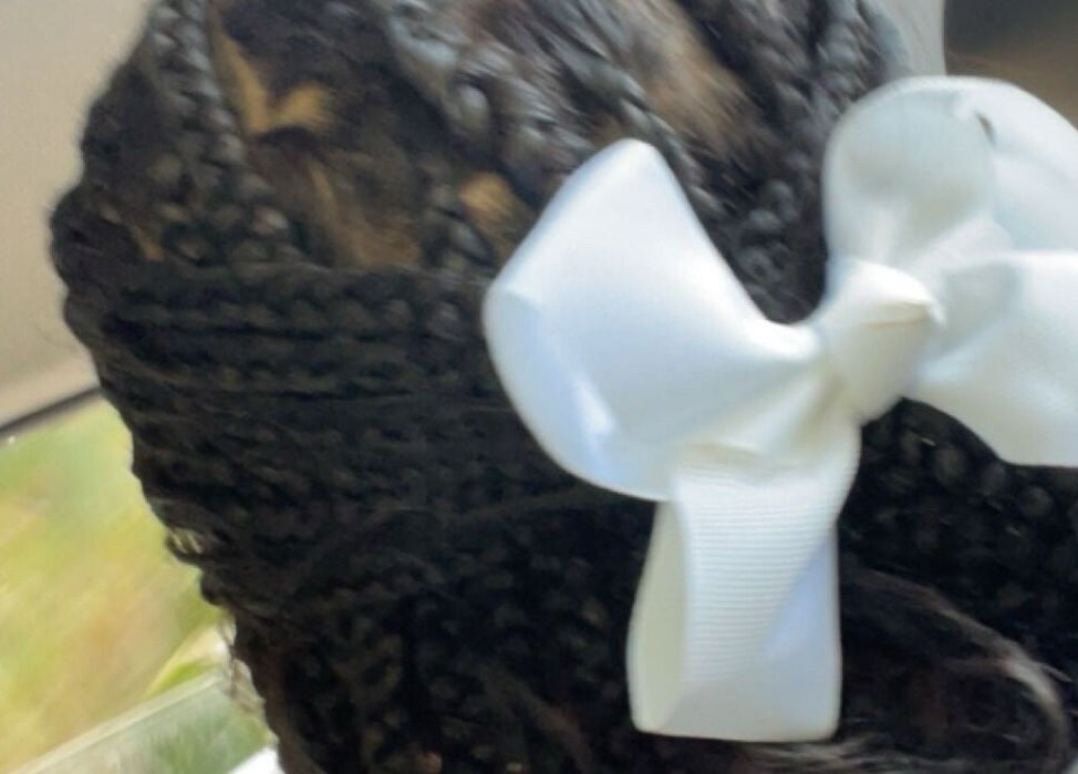 Elegant braided hairstyle with white bow at TTLC, Pembroke, BM.
