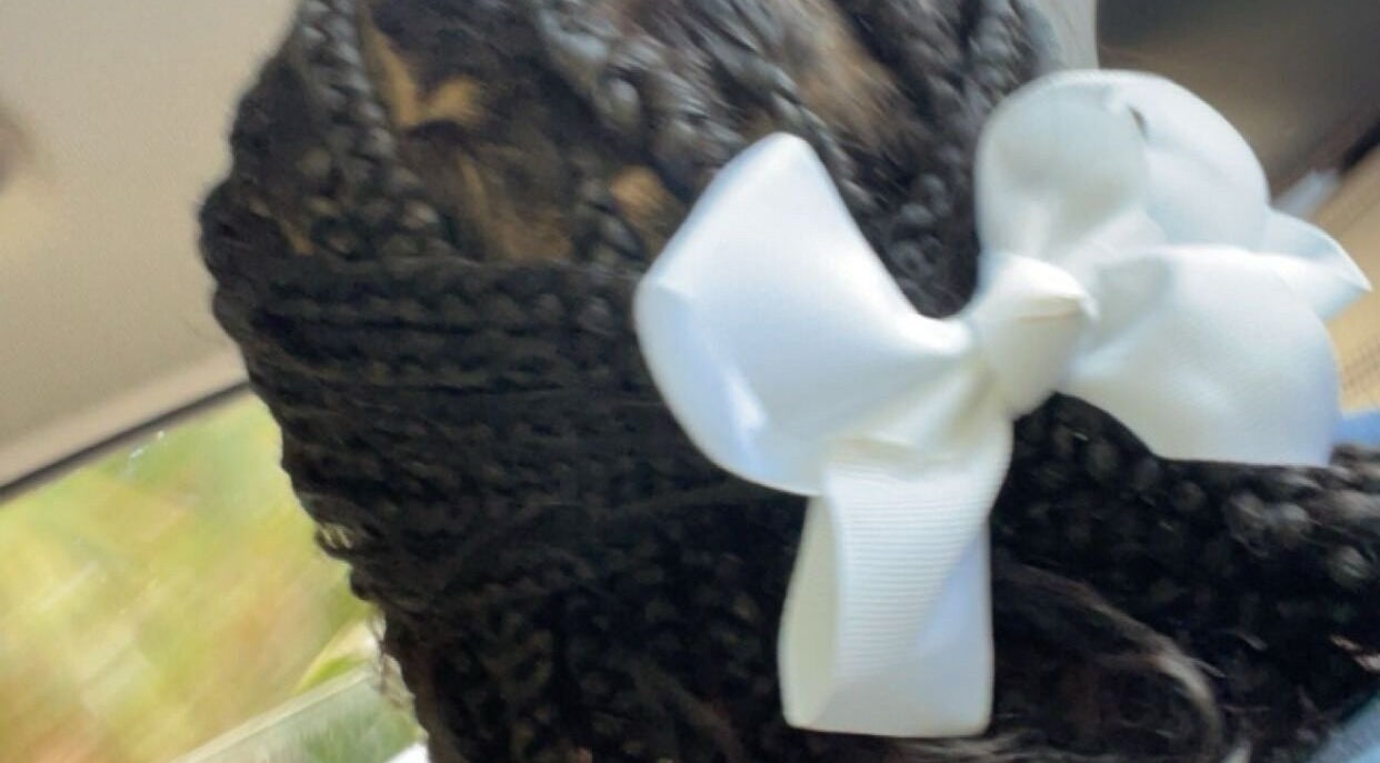 Elegant braided hairstyle with white bow at TTLC, Pembroke, BM.