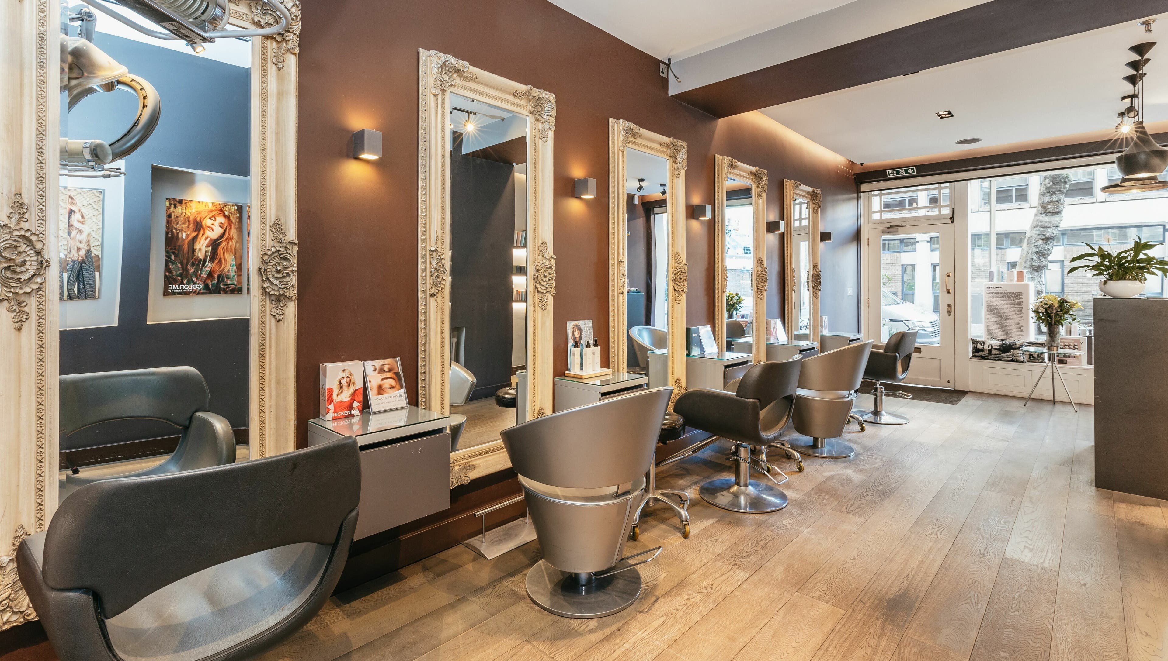 Elegant salon interior at Decadence Hair and Beauty, London, England, GB with ornate mirrors and modern chairs.