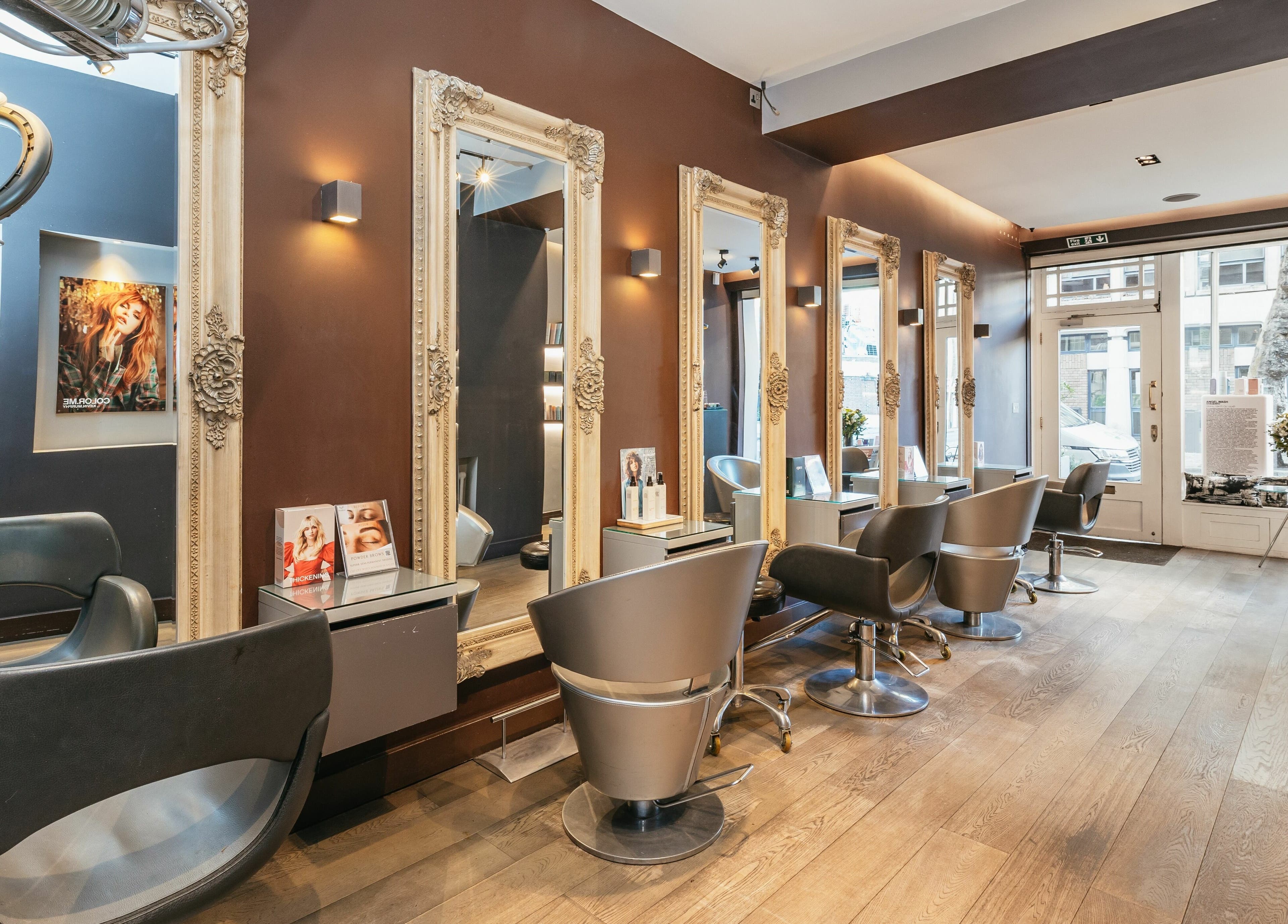 Elegant salon interior at Decadence Hair and Beauty, London, England, GB with ornate mirrors and modern chairs.