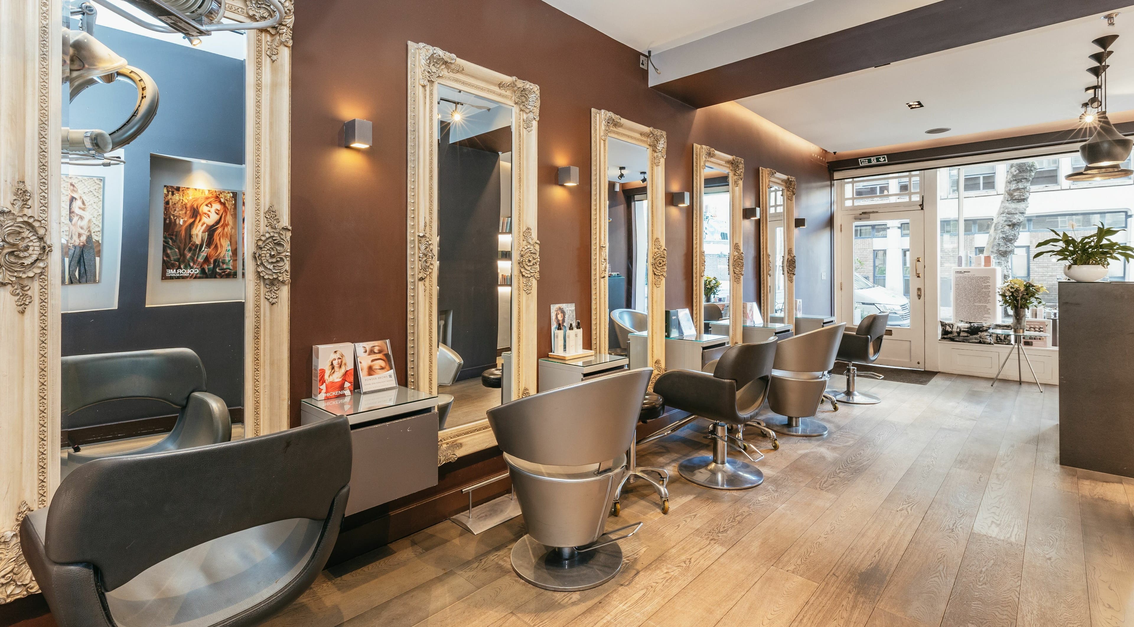 Elegant salon interior at Decadence Hair and Beauty, London, England, GB with ornate mirrors and modern chairs.