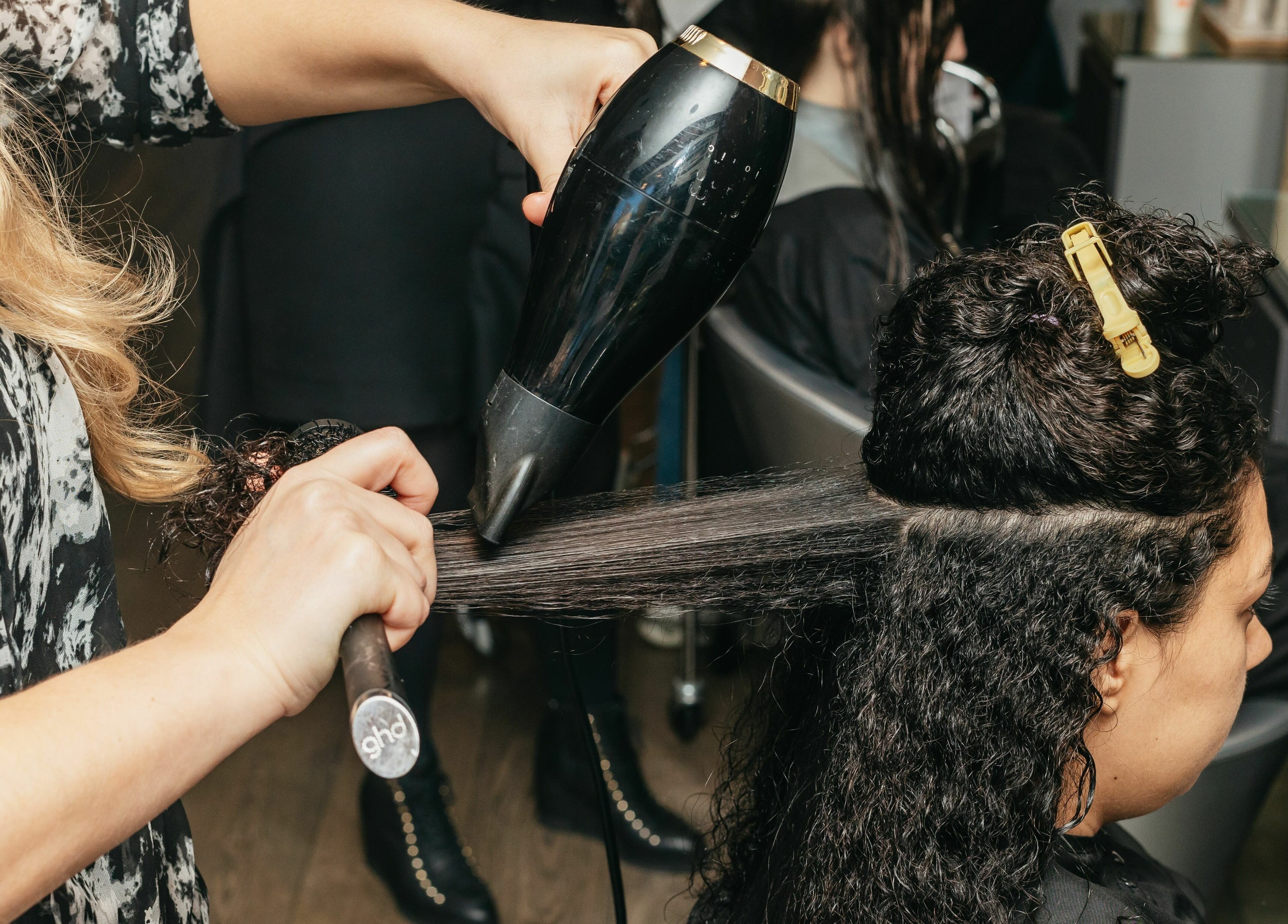 Stylist performing a chic blowout at Decadence Hair and Beauty, London, England, GB.