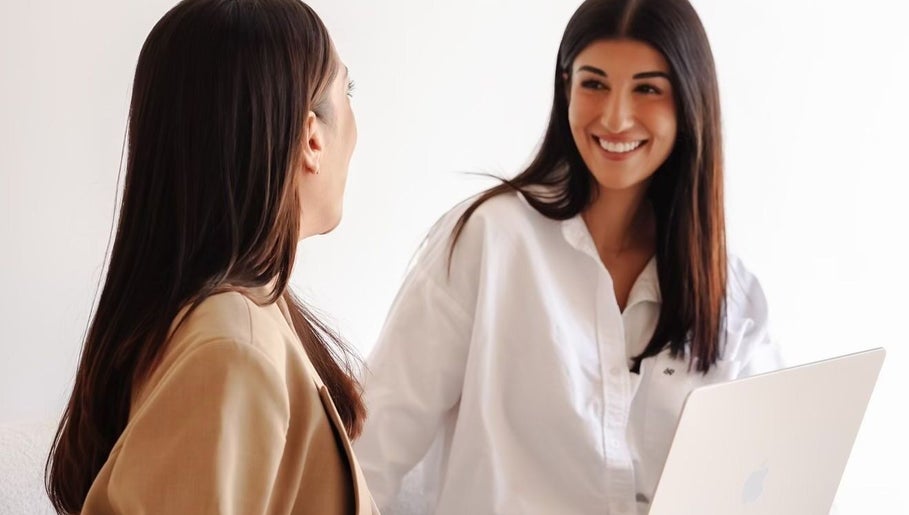 Two women sharing a happy moment at Beja Aesthetics, Rosebery, New South Wales, AU.