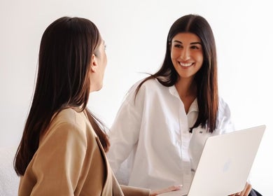 Two women sharing a happy moment at Beja Aesthetics, Rosebery, New South Wales, AU.
