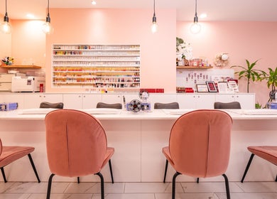 Chic beauty salon at Adora Haus, Port Melbourne, Victoria, AU with pink chairs and polish display.