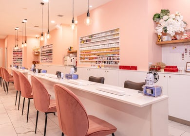 Stylish nail salon interior at Adora Haus, Port Melbourne, Victoria, AU with pink chairs and modern decor.