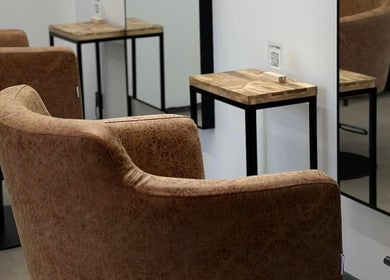 Теплый интерьер Clay Beauty Space в Таллине с комфортными креслами и деревянными столиками.