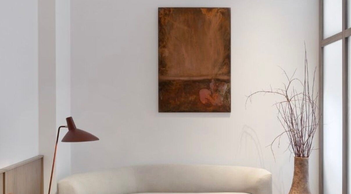 Elegant lounge at Hundred Folds Co, Singapore, SG with art piece, white couch, and rustic decor.