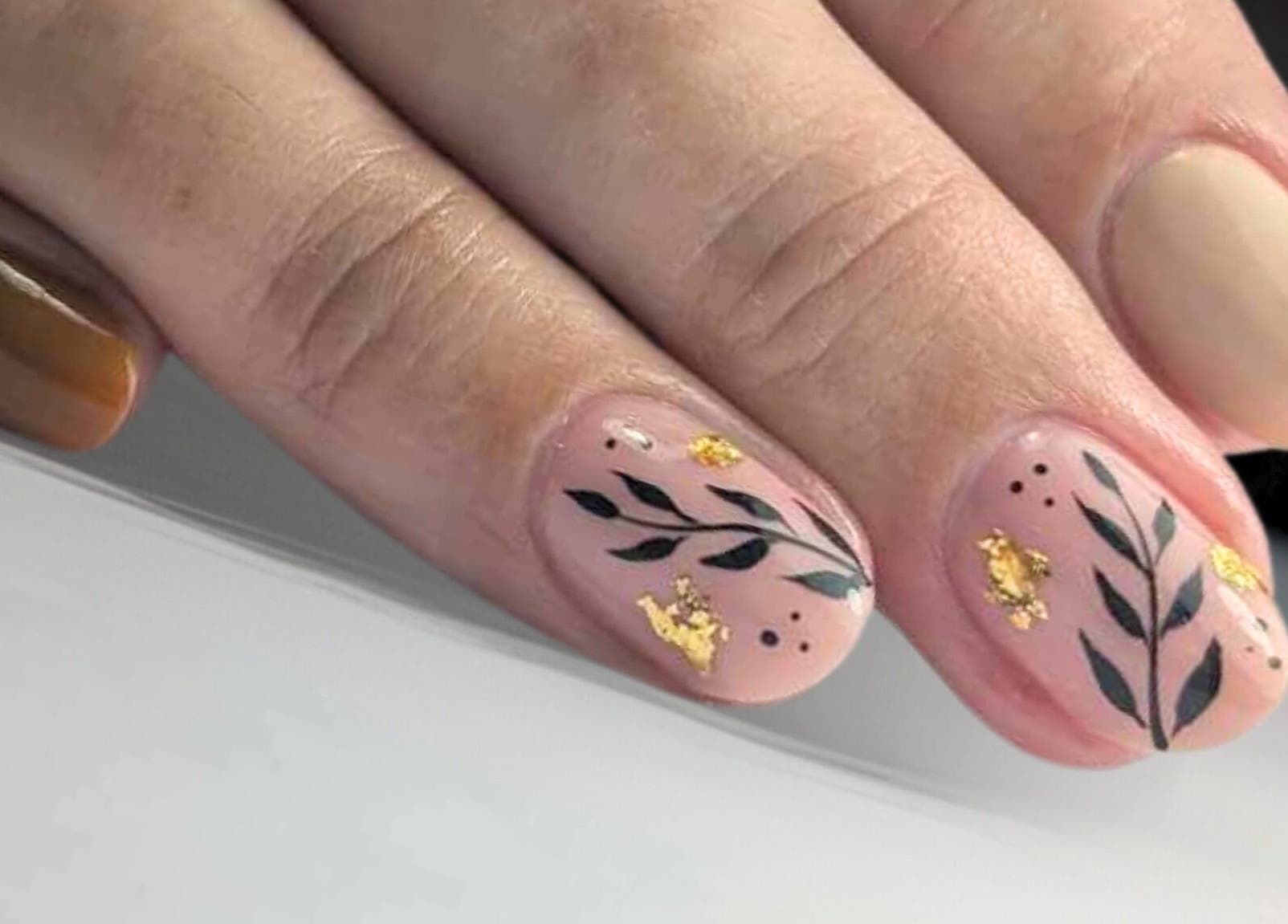 Design d'ongles raffiné avec motifs feuillus à Au Cœur des Ongles, Marmagne, Bourgogne-franche-comté, FR.