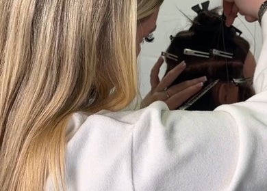 Stylist at EM Hair, Seaton Delaval, England, GB meticulously attaching hair extensions.