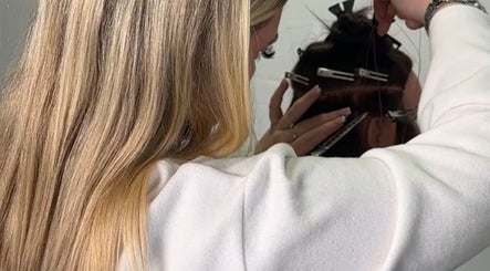Stylist at EM Hair, Seaton Delaval, England, GB meticulously attaching hair extensions.