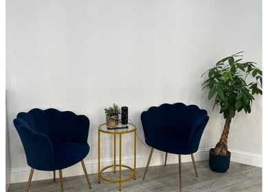 Elegant seating area at Hennylash, London, England, GB with plush chairs and a potted plant.