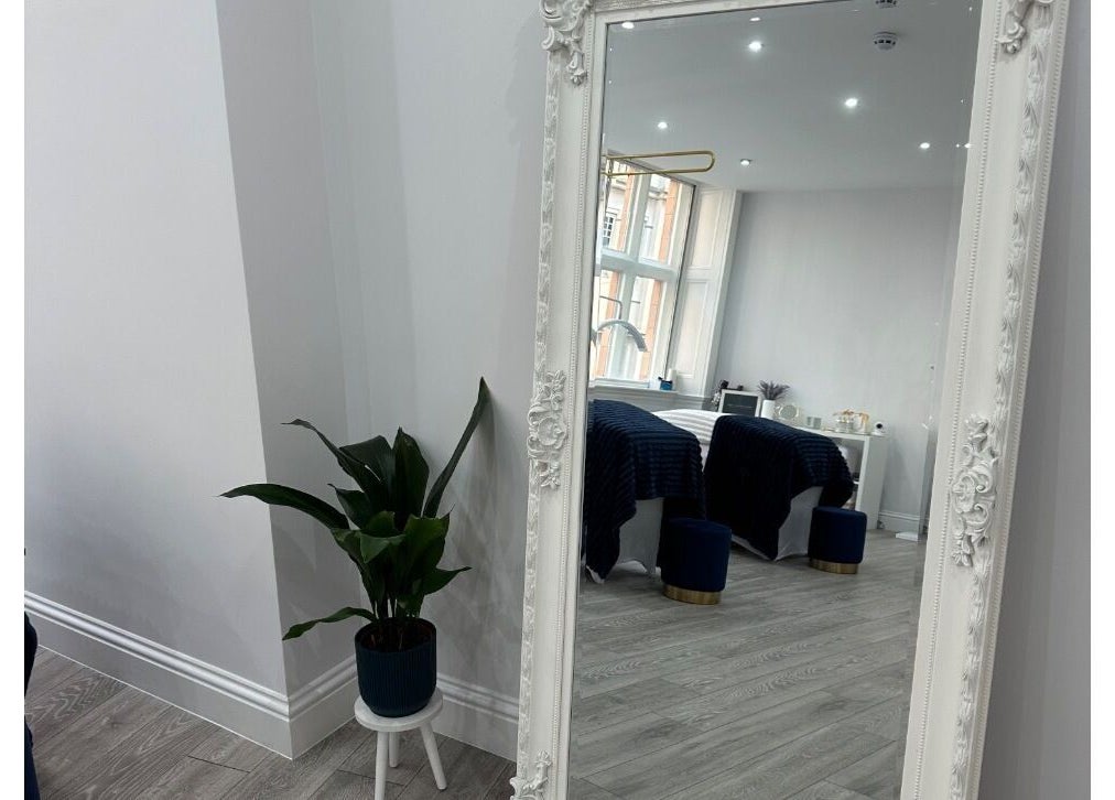 Elegant beauty room at Hennylash, London, England, GB, with a large ornate mirror and potted plant.