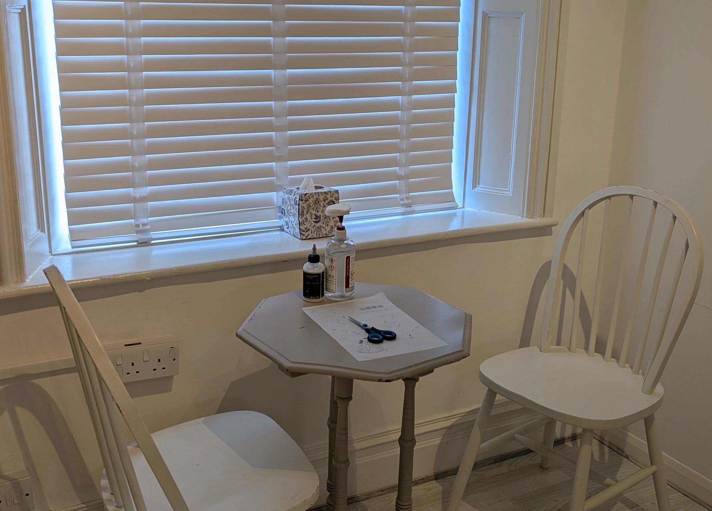 Cozy workspace at All Things Ink by Kaydee in Clitheroe, England, GB, featuring a table and chairs by a window.