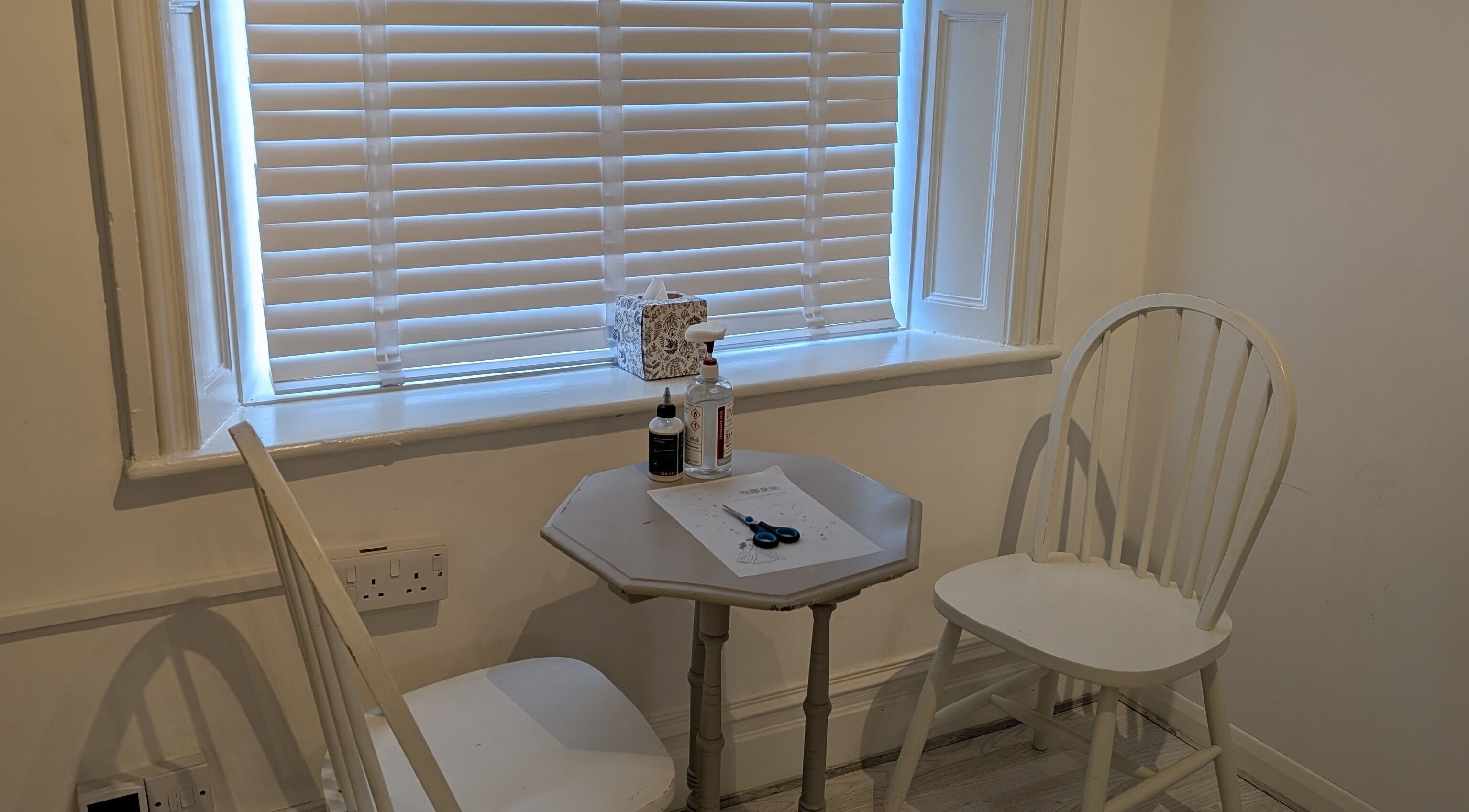 Cozy workspace at All Things Ink by Kaydee in Clitheroe, England, GB, featuring a table and chairs by a window.