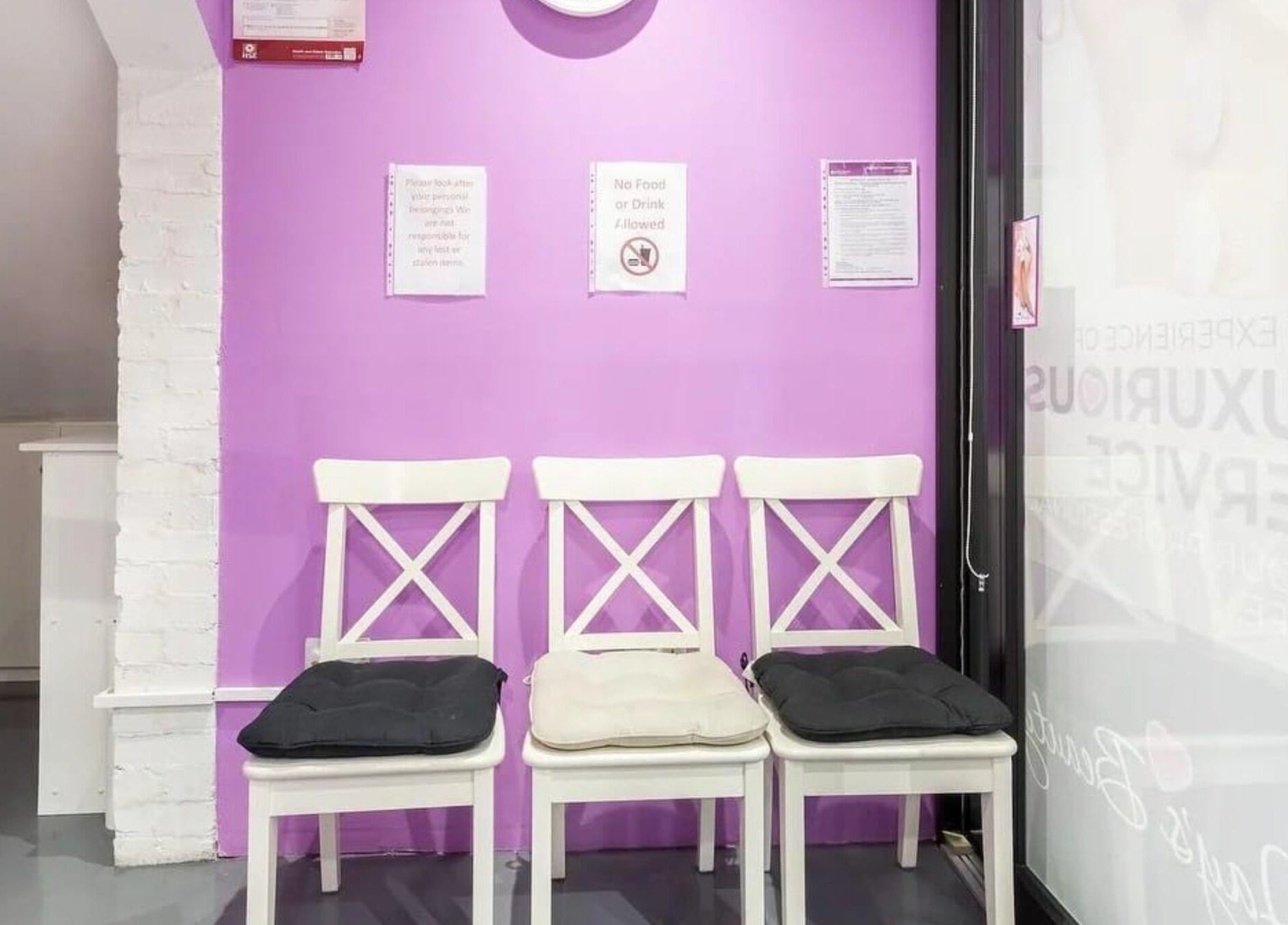 Stylish chairs against a purple wall at Jay's Beauty - Ladies Only in Hounslow, England, GB lobby.
