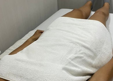 Cliente relaxando no Cliniquè Estética e Bem Estar, São Paulo, São Paulo, BR em uma mesa de spa.