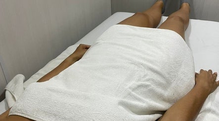 Cliente relaxando no Cliniquè Estética e Bem Estar, São Paulo, São Paulo, BR em uma mesa de spa.