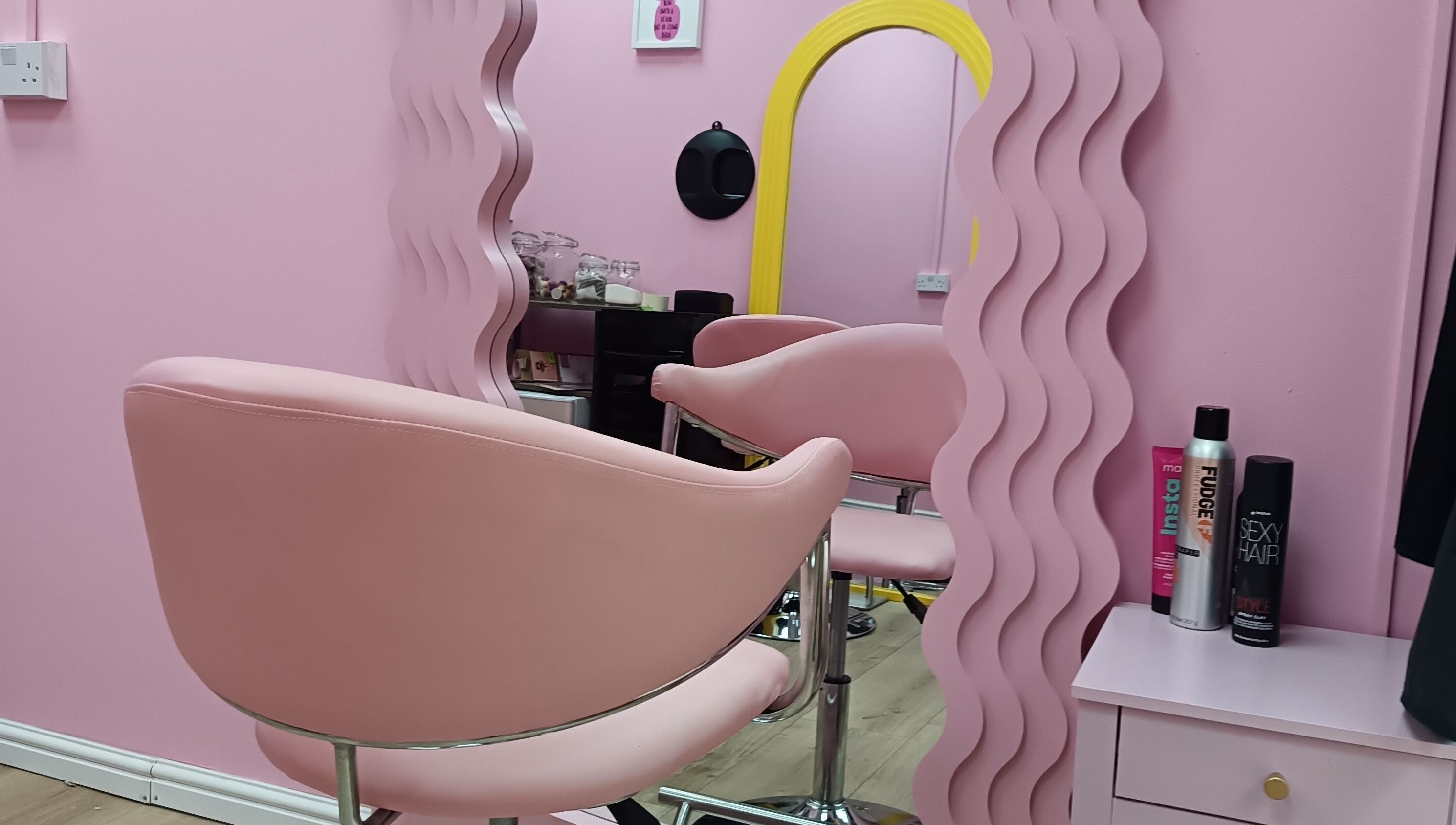 Modern pink salon chair and mirror at Franks, Cheadle, England, GB, offering stylish beauty services.