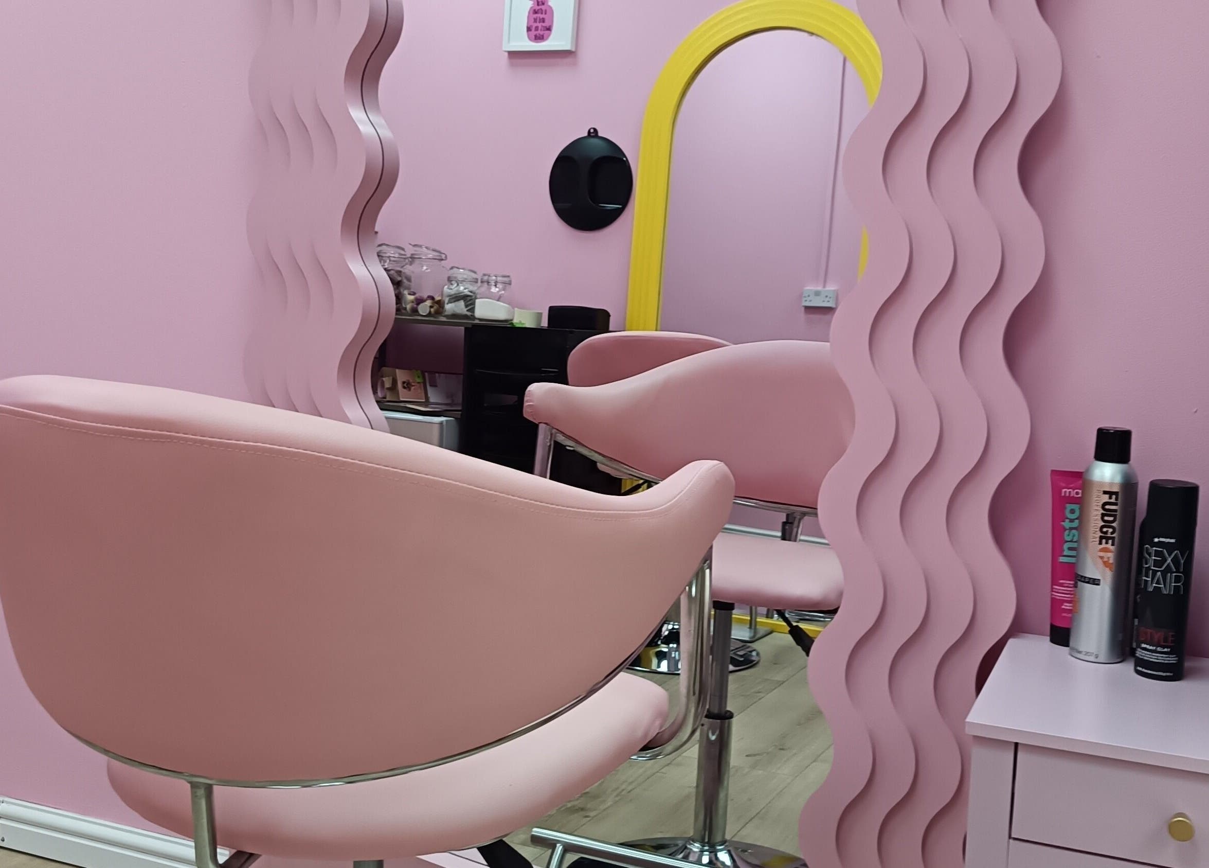 Modern pink salon chair and mirror at Franks, Cheadle, England, GB, offering stylish beauty services.