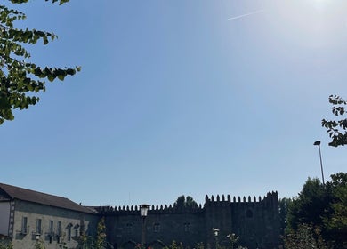 Vista de edifícios históricos perto do Mamuska Concept Beauty em Braga, Braga, PT, sob um céu azul claro.