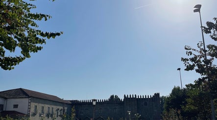 Vista de edifícios históricos perto do Mamuska Concept Beauty em Braga, Braga, PT, sob um céu azul claro.