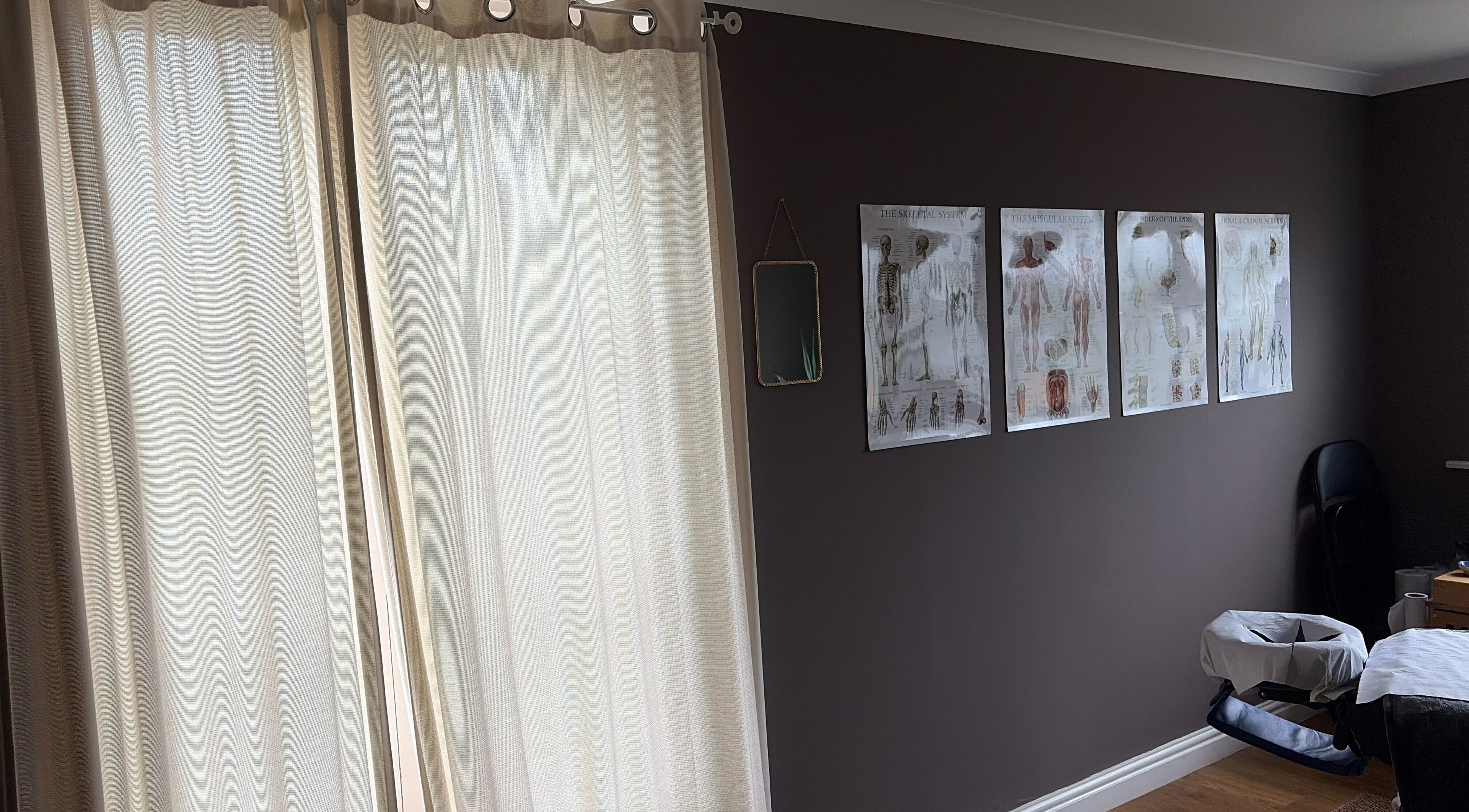 A serene therapy room at Phoebe’s Recovery Zone, Goodrich, England, GB with anatomical charts and soft lighting.