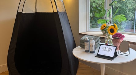 Spray tan setup at Bronzed by Chlo, Manchester, England, GB featuring sunflowers and tanning products.