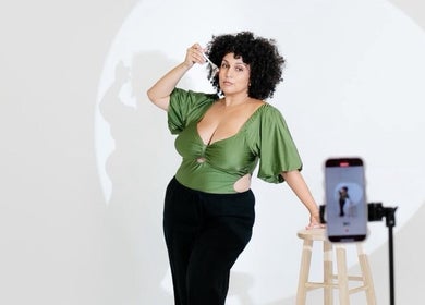 Woman posing at The SKVN Studio, Fleming Island, Florida, US, with phone capturing the moment.