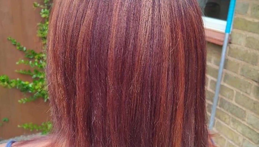 Rich copper hair color treatment at Chlos hair, Newport, England, GB. Highlighting glossy, smooth finish.