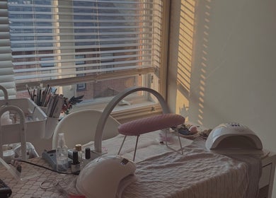 Nail care setup at Micah N Manis in Montréal, Québec, CA with tools and gel lamps by a sunlit window.