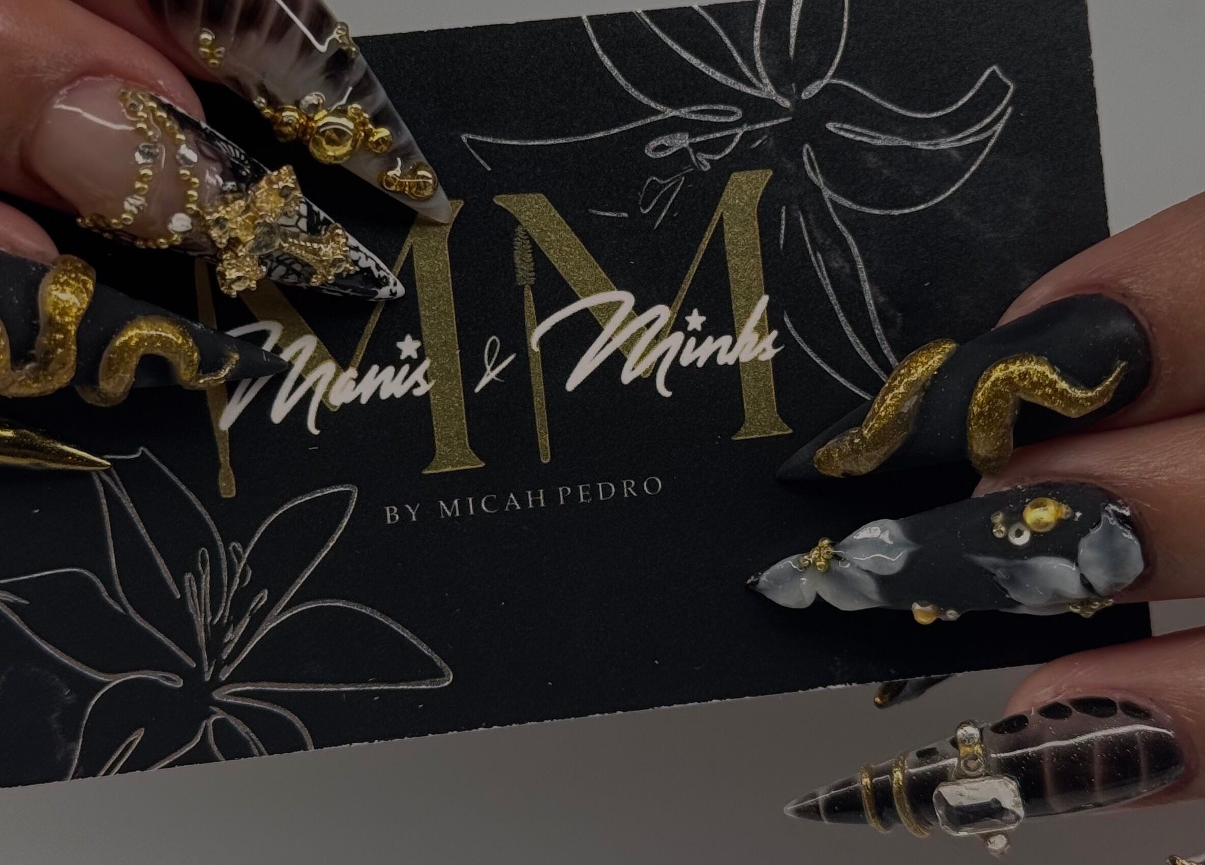 Intricate golden nail art at Manis & Minks in Montréal, Québec, CA, showcasing exquisite craftsmanship.
