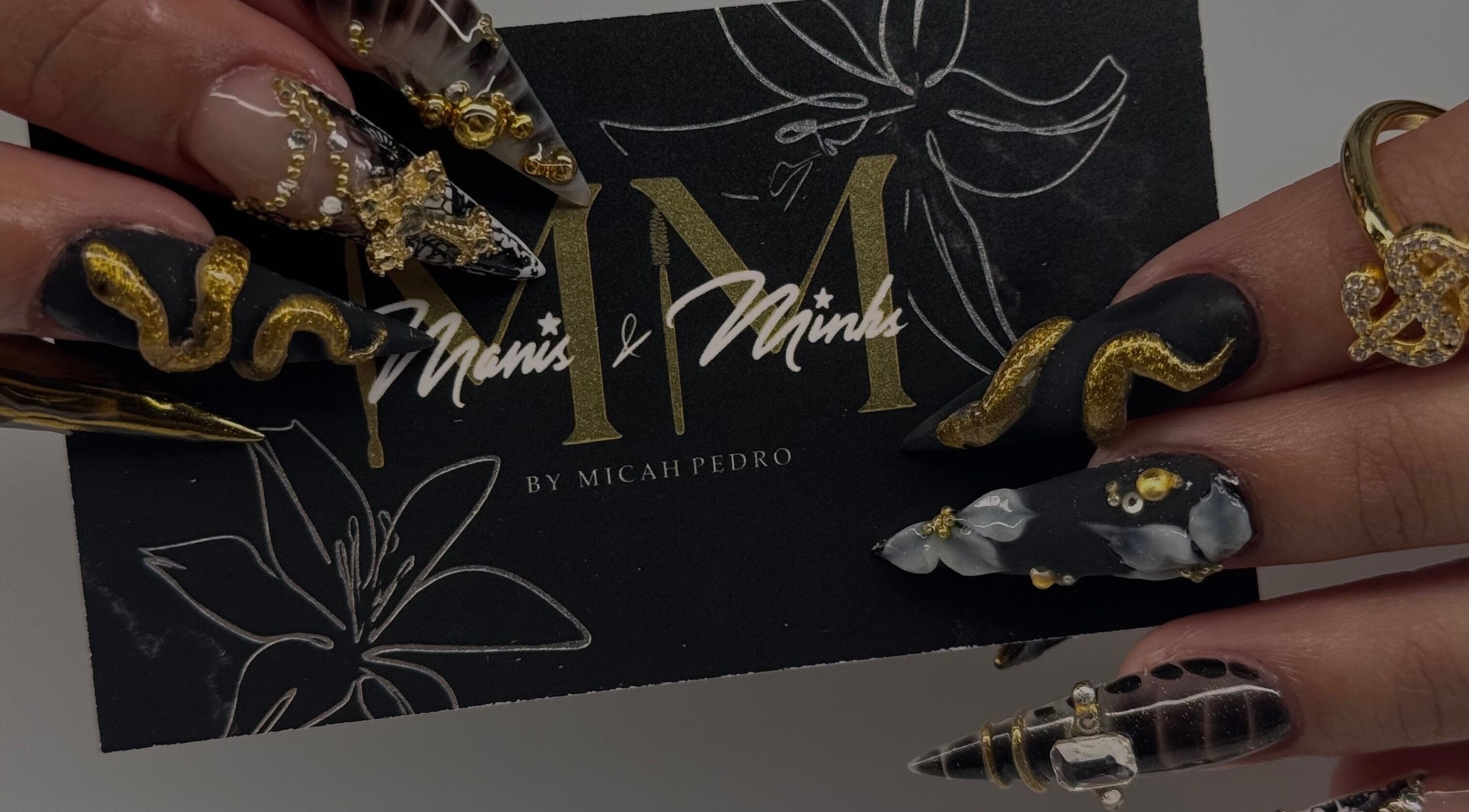 Intricate golden nail art at Manis & Minks in Montréal, Québec, CA, showcasing exquisite craftsmanship.