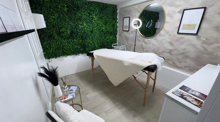 Treatment room at ML Aesthetics in Accrington, England, GB with lush green wall and cozy decor.