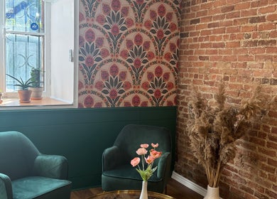 Charmant coin salon à État Sauvage, Montréal, Québec, CA avec fauteuils verts et déco botanique.