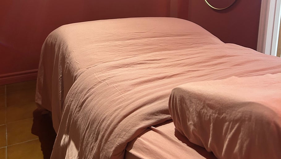 Lit de massage rose à État Sauvage, Montréal, Québec, CA, offrant détente et confort.