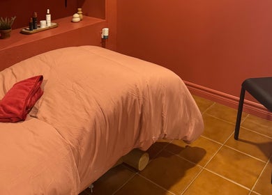 Salle de massage apaisante à État Sauvage, Montréal, Québec, CA, avec literie chaleureuse et décoration élégante.