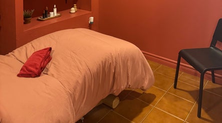 Salle de massage apaisante à État Sauvage, Montréal, Québec, CA, avec literie chaleureuse et décoration élégante.