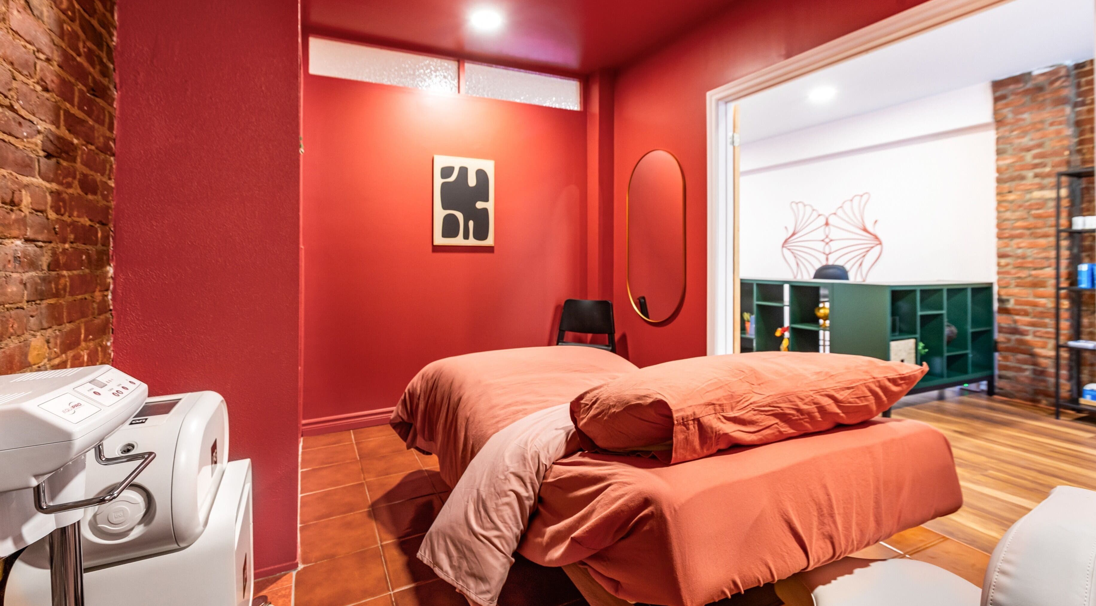 Salle de massage rouge à État Sauvage, Montréal, Québec, CA, offrant un cadre apaisant et élégant.