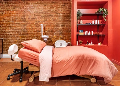 Salle de soin relaxante chez État Sauvage, Montréal, Québec, CA, avec mur en briques et lit de massage.