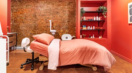 Salle de soin relaxante chez État Sauvage, Montréal, Québec, CA, avec mur en briques et lit de massage.