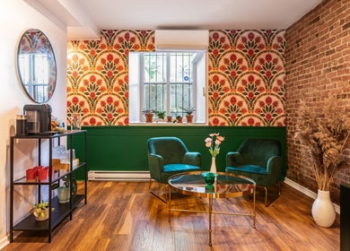 Salon chic à État Sauvage, Montréal, Québec, CA, avec des fauteuils verts et décor vintage.