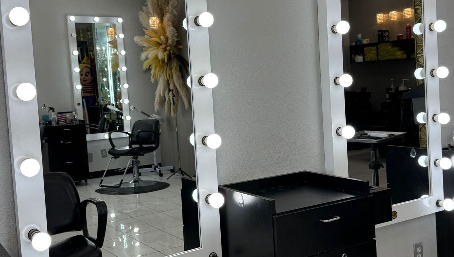 Espejo iluminado en el interior de By Cantu Salón, Dallas, Texas, US, mostrando una silla de estilista.