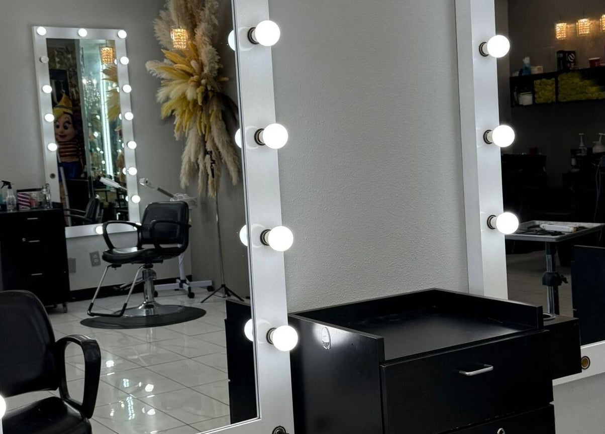 Espejo iluminado en el interior de By Cantu Salón, Dallas, Texas, US, mostrando una silla de estilista.