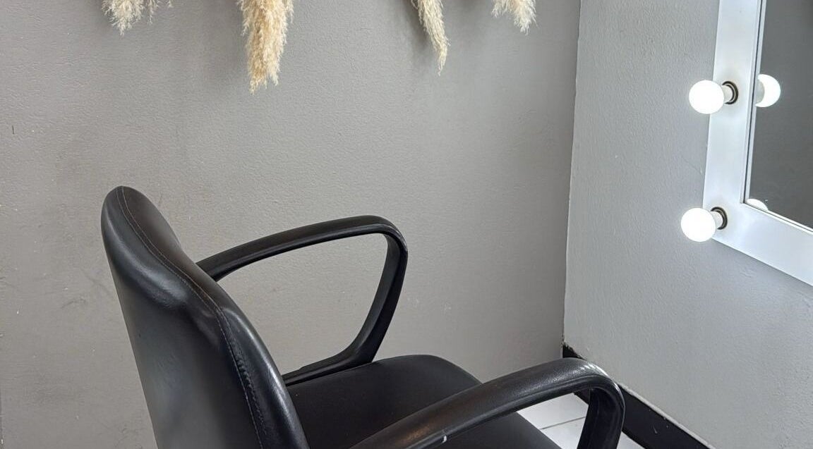 Silla de peluquería moderna junto a espejo iluminado en By Cantu Salón, Dallas, Texas, US.