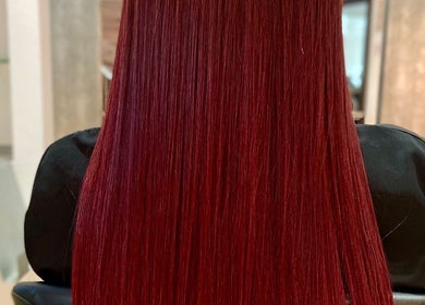 Intenso cabello rojo en silla de Hair Brasil by Virgínia, Barcelona, ES.