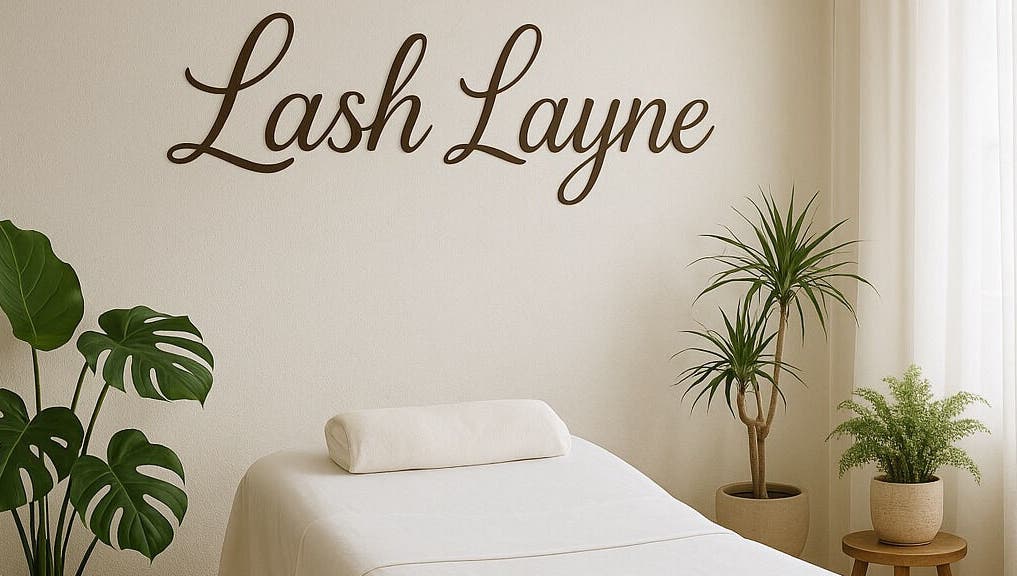 Tranquil treatment room at Lash Layne, Azle, Texas, US with plants and a cozy massage bed.
