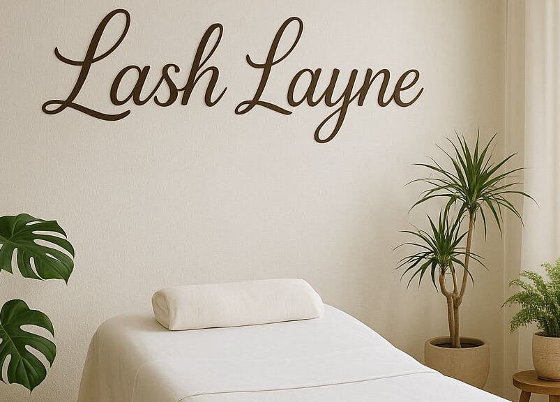 Tranquil treatment room at Lash Layne, Azle, Texas, US with plants and a cozy massage bed.